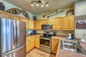 a kitchen with wooden cabinets and a stainless steel refrigerator at Hidden River Lodge 5975 in Keystone +11 photos