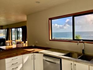 a kitchen with a sink and a view of the ocean at 90 Mile Paradise Ahipara in Ahipara