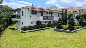 a large white building with a yard at Villa Karina in Kolios