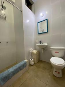 a bathroom with a toilet and a sink at Hostal Lobitos in Cerro Azul +22 photos