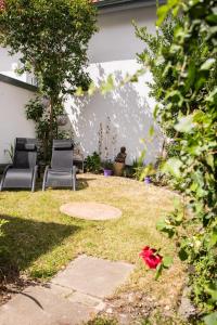 a yard with two chairs and a tree at ME LIVING Ferienhaus 130qm Lemgo Zentrum in Lemgo
