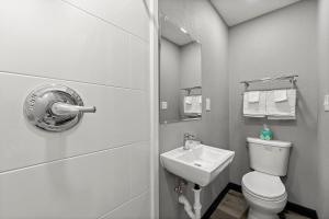 a white bathroom with a toilet and a sink at Southern Suites Kennesaw in Kennesaw +1 photo