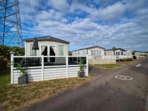 a house with a white fence on the side of a road at The Ticehurst Haven in Westgate-on-Sea