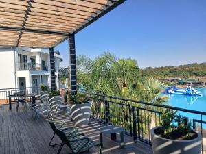 balcone con sedie e vista sulla piscina di The Blyde Lifestyle Resort Luxury Pozi a Pretoria
