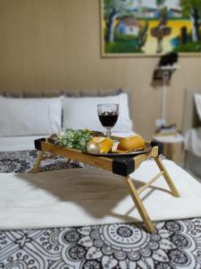 bandeja de comida y copa de vino en la cama en Bella Vista Loft, en Petrolina