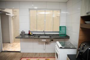 una cucina con un lavandino e una finestra di Sobrado com 03 quartos, prox aduana da Argentina a Foz do Iguaçu