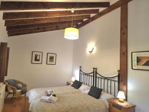 a bedroom with a bed in a room with wooden beams at El Tirao de Suesa - 34800 in Suesa