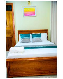 a bedroom with a large bed with blue pillows at Cherryhomes at Mbezi Juu in Dar es Salaam