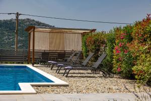 eine Gruppe von Stühlen neben einem Swimmingpool in der Unterkunft Urlaubsdomizil in Kroatien - willkommen in Bribir