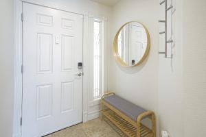 a hallway with a mirror and a bench next to a door at Dwell Descans - Restful Haven Steps to Vegas Strip in Las Vegas