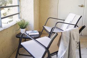 two chairs and a table on a porch at Dwell Descans - Restful Haven Steps to Vegas Strip in Las Vegas