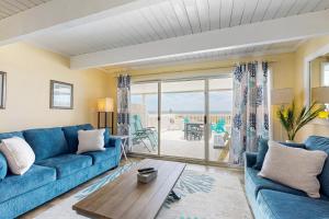 a living room with a blue couch and a view of the ocean at Ocean Colony 3 in Ocean City