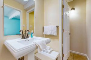 a white bathroom with a sink and a mirror at Ocean Colony 3 in Ocean City