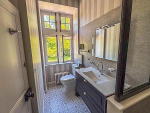 un bagno con lavandino, WC e specchio di Domaine de Kerrosen à proximité du port de Dinan, sur la Rance a Taden