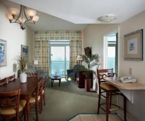 Holiday Sands at South Beach في ميرتل بيتش: غرفة طعام وغرفة معيشة مع طاولة وكراسي