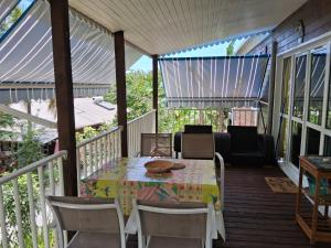 a screened porch with a table and chairs on it at Gite poisson in Bouillante