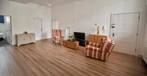 a living room with two chairs and a television at Iconic Apartment - Littleborough in Littleborough