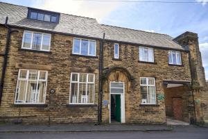 an old brick house with a green door at Iconic Apartment - Littleborough in Littleborough
