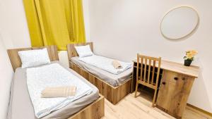 a room with two beds and a mirror and a crib at Spacious Rooms - 15 Min from Airport & City Center, 5 Min from Vienna Main-Bus Station EZ 12 in Vienna