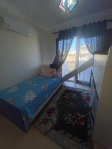 a small bedroom with a bed and a window at فيلا دوبلكس في العين السخنة في قرية بلو باي أسيا عروس السخنة in Ain Sokhna +32 photos