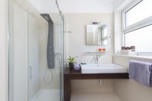 a white bathroom with a sink and a shower at Villa Vera in Novigrad Istria