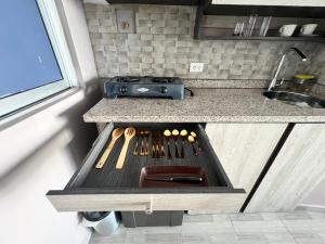a kitchen with a stove and a grill with cooking utensils at Aparta estudio en el edificio bahia 79 apartasuites in Cartagena de Indias