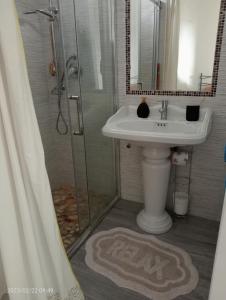 une salle de bain avec un lavabo et une douche avec un miroir dans l'établissement Tenuta Ornella, à Miglianico 9 autres photos