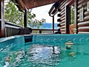 a pool of water in front of a house at Gorgeous View. Hot Tub. Privacy. Fireplace. Pool & Fishing Access! in Sevierville
