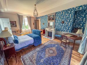 una camera da letto con pareti blu, un letto e un camino di Domaine de Kerrosen à proximité du port de Dinan, sur la Rance a Taden