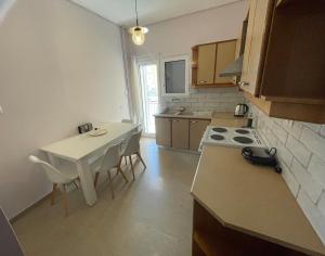 a small kitchen with a table and a stove at Iris Central Home in Kalamata