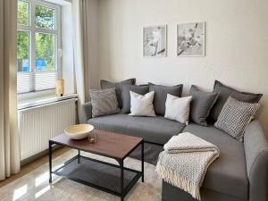 a living room with a gray couch and a table at LS FeWo Bad Doberan - gemütlich, praktisch, zentral in Bad Doberan