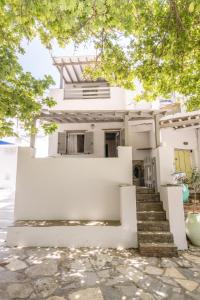 a white house with stairs in front of it at Apopsis Tinos Square in Triandáros