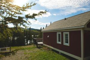 a red house with a bench next to it at Chalet des Boisés 10 in Murdochville