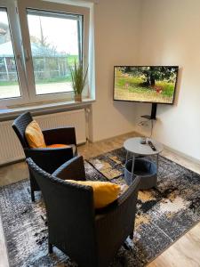 a living room with chairs and a flat screen tv at Hof Uffenbeck - Apartment 5, auf dem Land in Melle