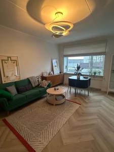 a living room with a green couch and a table at Composer's apartment in Tallinn