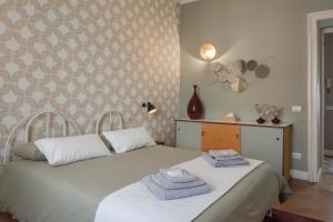 a bedroom with two beds with towels on them at Eleganza e comfort in centro in Ivrea +13 photos