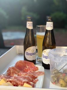 two bottles of beer and a plate of food at Natuurhuis 'Van De Wereld' in Lanaken