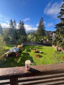 a cup of coffee sitting on a bench with a yard at Garden Apart&Rooms Predeal in Predeal +87 photos