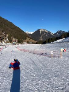 a person riding a snowboard down a snow covered slope at Le pied des pistes, studio 5 pers, balcon sud est, vue sur les montagnes in Le Biot