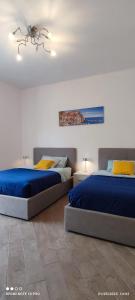 een slaapkamer met 2 bedden en een kroonluchter bij Stephy Holiday Station 5 Terre in La Spezia