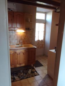 Una cocina con gabinetes de madera y un fregadero. en Gîte Dornecy, en Dornecy