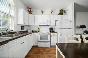 eine Küche mit weißen Schränken und einem weißen Kühlschrank in der Unterkunft The Sweetgrass - 57 Butternut in Cherry Valley