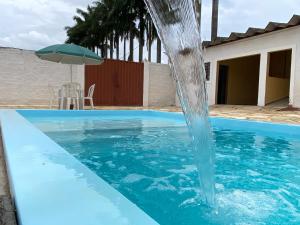 a water fountain in the middle of a swimming pool at Pousada Recanto das Palmeiras in Areado