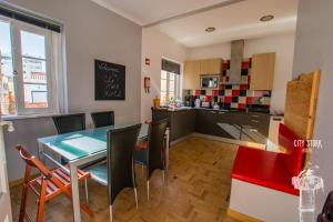 cocina y comedor con mesa y sillas en City Stork Hostel en Portimão