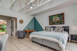 a bedroom with a bed and a desk and a chair at Sitatunga Guest Lodge - Sandton - Airport Shuttle - Solar & Borehole in Johannesburg