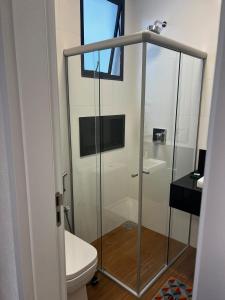 a bathroom with a glass shower with a toilet at Guaja 745 - Apartamento Luca in Belo Horizonte