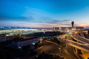 eine nächtliche Aussicht auf eine Stadt mit einer Brücke in der Unterkunft Pullman Nanjing Lukou Airport in Nanjing