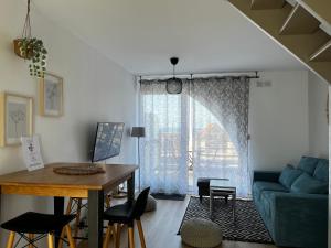 salon ze stołem i niebieską kanapą w obiekcie LA MER EN VUE, destination naturelle pour 2, avec WIFI et parking w mieście Wimereux