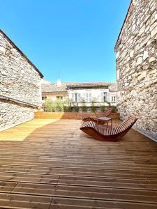two benches sitting on a wooden deck in a building at Suite Altana in Montélimar +5 photos