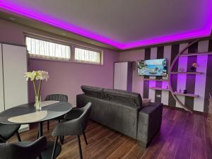 a living room with a couch and a table with chairs at Penthouse Happy Seasons in Hajdúszoboszló